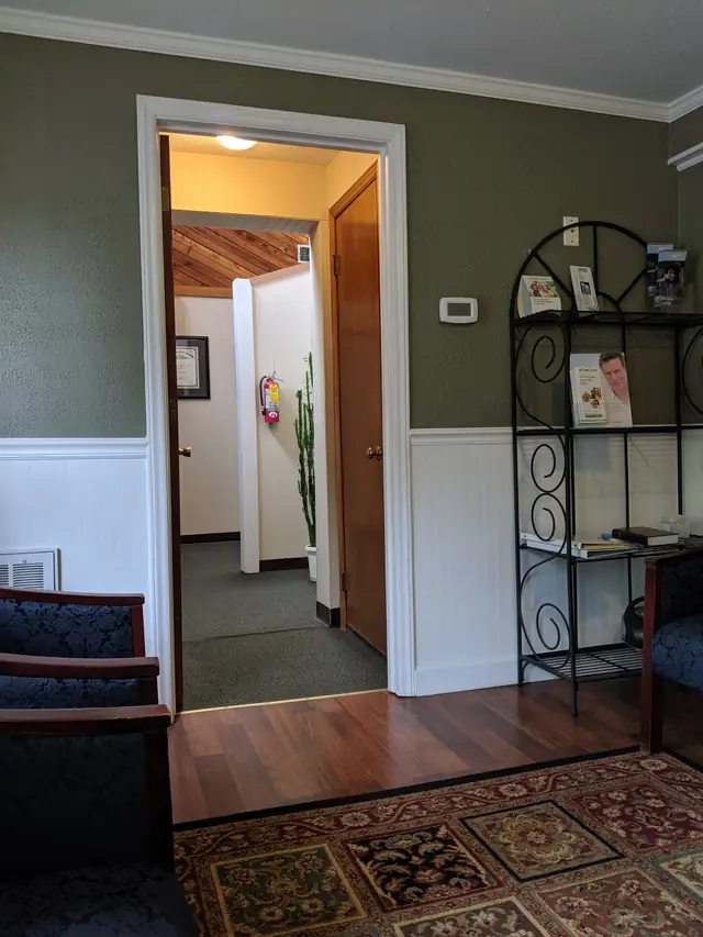 The doorway from the waiting room into the treatment hallway, wood floor and rug