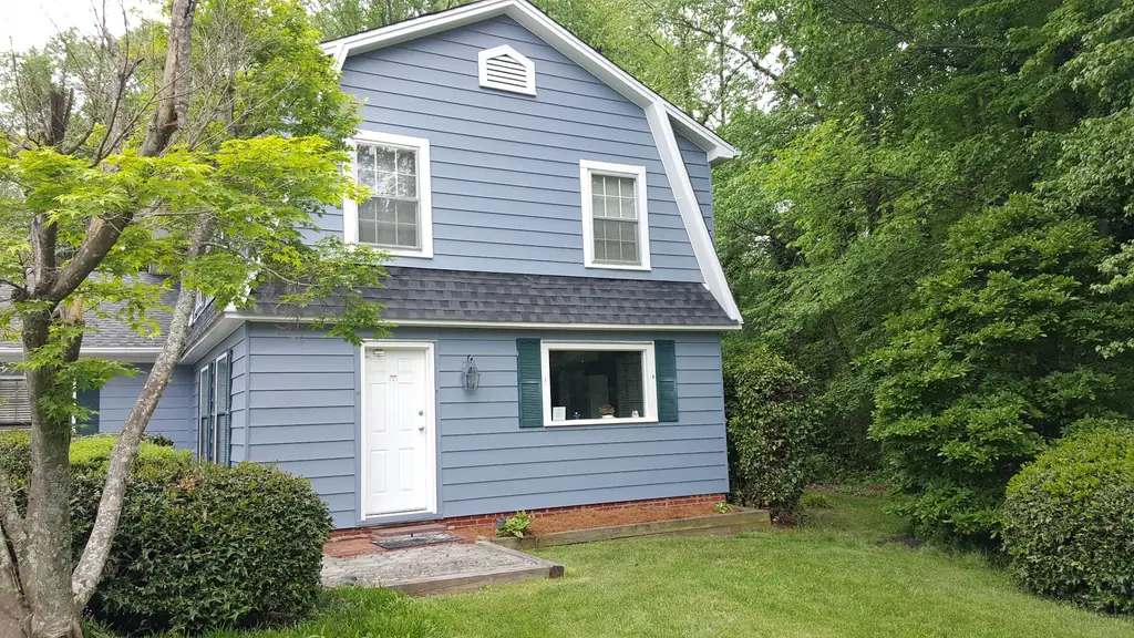 The front of the blue clinic building at 231 Baker Road, lawn and trees